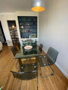 Un comedor con una mesa de cristal y sillas. en Luxurious appartement Montreuil, en Montreuil