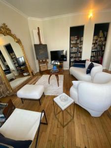 sala de estar con muebles blancos y espejo grande en Luxurious appartement Montreuil, en Montreuil