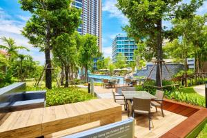 a patio with tables and chairs in a park at unixx city ​​center high floor amazing sea view24f in Pattaya South