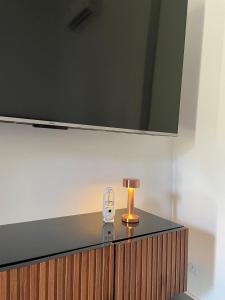 einen Tisch mit einer Lampe und einen TV darüber in der Unterkunft Airanda Phuket Homestay in Ban Suan