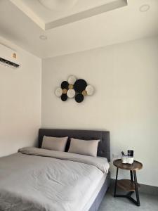 Airanda Phuket Homestay في Ban Suan: غرفة نوم بسرير وساعة على الحائط