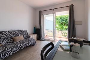 Una sala de estar con un sofá y una mesa de cristal. en New familiar lovely apartment in Cala en Porter, en Cala'n Porter