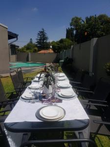 a long table with plates and wine glasses on it at Nid de Rêve Accomodation in Sandton