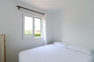 Un dormitorio con una cama blanca y una ventana. en New familiar lovely apartment in Cala en Porter, en Cala'n Porter 28 fotos más