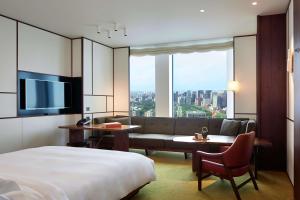 東京にあるアンダーズ東京 ア コンセプト バイ ハイアットのベッドとソファ付きのホテルルーム