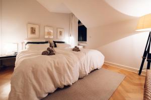 een slaapkamer met een groot bed met 2 teddyberen erop bij Tallskog - Dein Apartment am Naturstrand Hohen Wieschendorf in Hohenkirchen