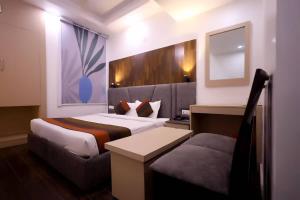 a hotel room with two beds and a couch at Hotel Krishna Sagar Ghaziabad in Ghaziabad