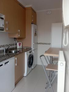 eine Küche mit einer Spüle und einer Waschmaschine in der Unterkunft Duplex con piscina VUT1230AS in San Juan de la Arena