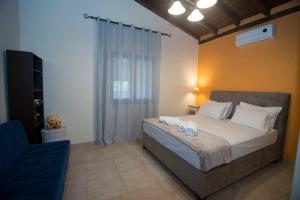 a bedroom with a bed and a blue chair at Villa Marina Limnos in Pedhinón
