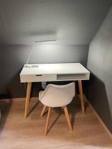a white desk with a chair and a lamp at Gite Au Chant d'Eole in Ebly