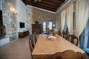uma sala de jantar com uma mesa e uma parede de pedra em Villa Marina Limnos em Pedhinón