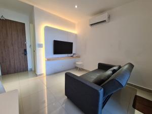 uma sala de estar com um sofá e uma televisão de ecrã plano em The Shore - JJ's Unit with City View em Kota Kinabalu