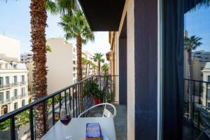 a balcony with a table and palm trees at Nyx Hôtel Indépendant Perpignan Centre Gare in Perpignan +50 photos