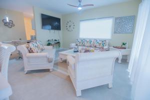 sala de estar con sillas blancas y mesa en Gadie Villa, en Punta Cana