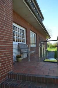 a brick building with a bench on a patio at Haus Widder Nr3 in Kopendorf