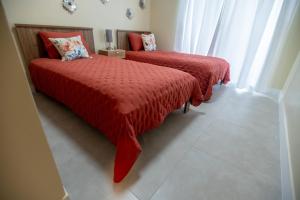 2 camas en una habitación con edredones rojos. en Gadie Villa, en Punta Cana