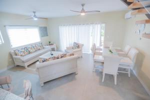 sala de estar con sofás, mesa y sillas en Gadie Villa, en Punta Cana