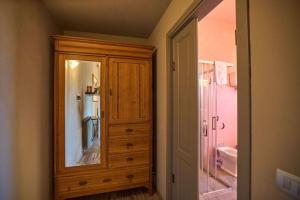 a bathroom with a wooden cabinet with a mirror at Az.Agr. Il Cavalleggero in Campiglia dʼOrcia