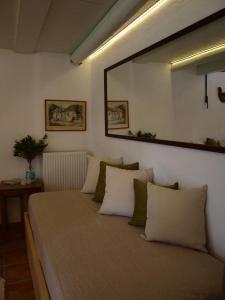 Bett in einem Zimmer mit einem Wandspiegel in der Unterkunft Country House Spitaki Λόχος in Velika