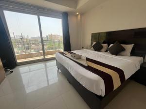 a bedroom with a large bed with a large window at TIPSYY INN 007 in Gurgaon