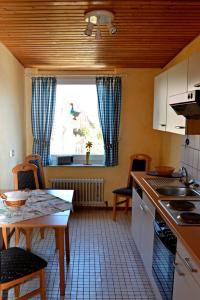 a kitchen with a sink and a table and a window at Haus Widder Nr2 in Kopendorf