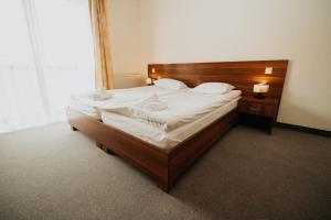 sypialnia z dużym łóżkiem z drewnianym zagłówkiem w obiekcie Noclegi - Apartamenty Żołynianka w mieście Żołynia