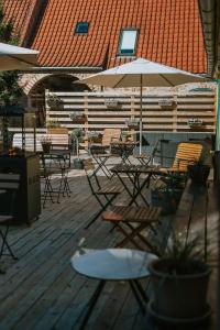 una terraza con mesas, sillas y sombrilla en KEFS Guesthouse & Café en Ærøskøbing