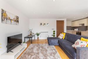 a living room with a blue couch and a fireplace at Modern Two Bedrooms Flat in Kingston KT2, London in Kingston upon Thames