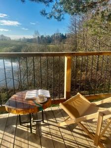 a table and chairs on a balcony with a view of a river at Watrosówka in Pasym