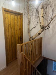 a room with a wooden door and a tree on the wall at Watrosówka in Pasym