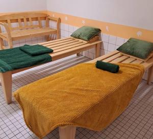 a room with two wooden beds with green blankets at Schwarzwald-Traum mit Pool und Sauna in Unterkirnach