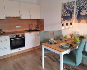 a kitchen with a wooden table with chairs and a dining room at Schwarzwald-Traum mit Pool und Sauna in Unterkirnach
