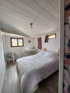 um quarto com uma cama, uma secretária e uma janela em Le refuge de daglan em Daglan