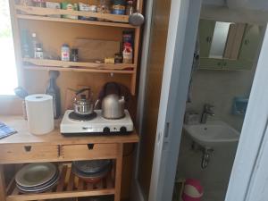 uma pequena cozinha com um fogão e um lavatório em Through the Grapevine House - peace and quiet em Egina