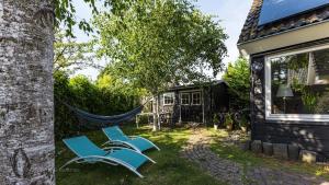 twee stoelen en een hangmat in de tuin van een huis bij De ZeeuwSter in Burgh Haamstede