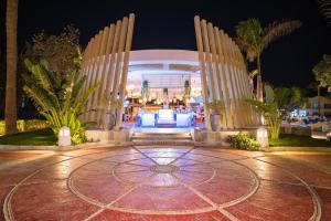 un edificio con due grandi colonne bianche di notte di Hotel Novotel Sharm El-Sheikh a Sharm El Sheikh