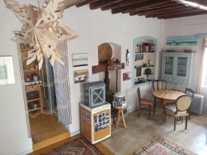 uma sala de estar com uma mesa e um lustre em Through the Grapevine House - peace and quiet em Egina