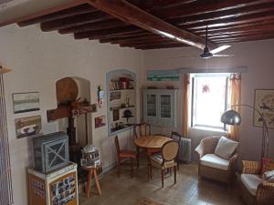 uma sala de estar com uma mesa e uma janela em Through the Grapevine House - peace and quiet em Egina