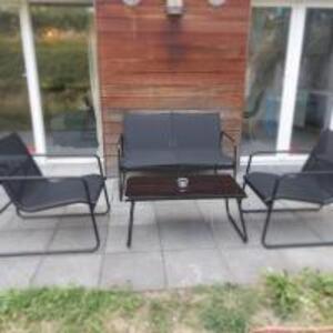 3 sillas y una mesa en un patio en kleine Wohnung in Köln-Rösrath mit Garten, en Rösrath