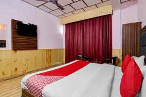 a bedroom with a bed and a television in it at OYO Hotel The Cloud Hills in McLeod Ganj