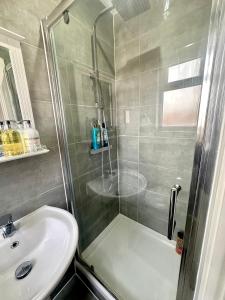 uma casa de banho com um chuveiro e um lavatório. em Wonderful Double Room In Wimbledon With Free Car Parking em Londres