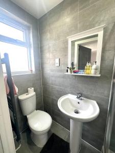 a bathroom with a toilet and a sink at Wonderful Double Room In Wimbledon With Free Car Parking in London