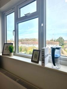 a window sill with pictures and a vase on it at Wonderful Double Room In Wimbledon With Free Car Parking in London