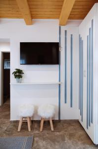 sala de estar con 2 bancos y TV de pantalla plana en Vízitündér Pihenőpark Apartmanok, en Újhartyán