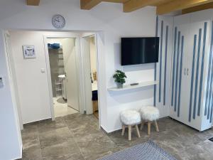 sala de estar con 2 taburetes y TV en Vízitündér Pihenőpark Apartmanok, en Újhartyán 50 fotos más