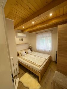 Un pat sau paturi într-o cameră la Vízitündér Pihenőpark Apartmanok