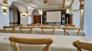 una sala conferenze con tavoli, sedie e schermo di Hotel Villa Frigiliana a Frigiliana