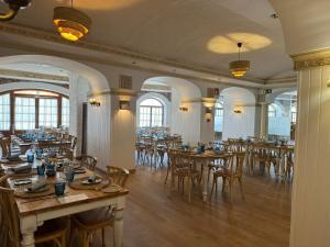 ein Restaurant mit Holztischen, Stühlen und Fenstern in der Unterkunft Hotel Villa Frigiliana in Frigiliana