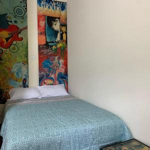 1 dormitorio con 1 cama con una pintura en la pared en Casa Campo Juive Grande en Riobamba