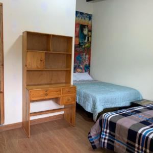 ein Schlafzimmer mit einer Holzkommode und einem Bett in der Unterkunft Casa Campo Juive Grande in Riobamba